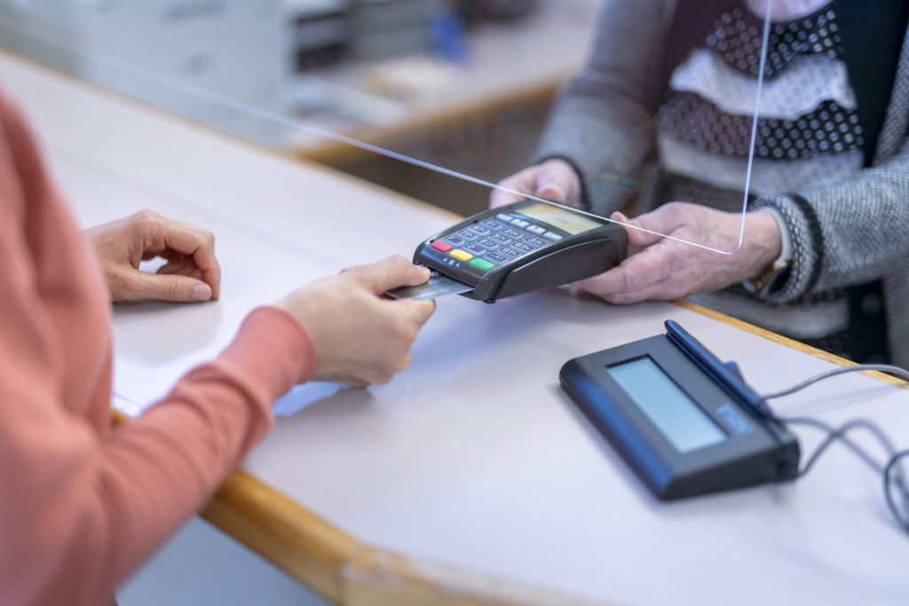 Customer paying with contactless credit card payment for medical services